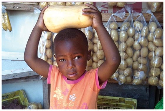     A boy in his father’s shop in Khayelitsha, South Africa. Postcard 1.10 by Nonkuthalo Nobangela